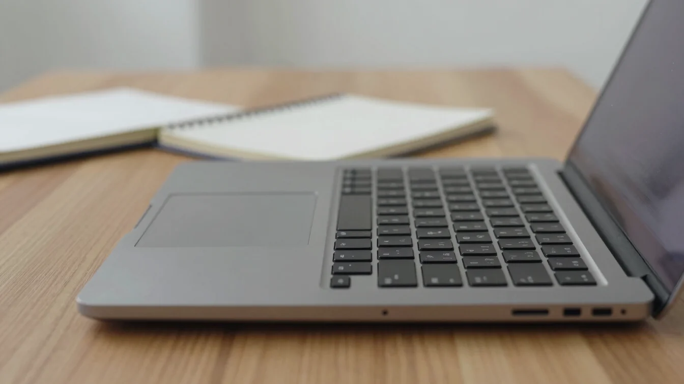 Documentary close detail of a laptop keyboard and a notebook on a
